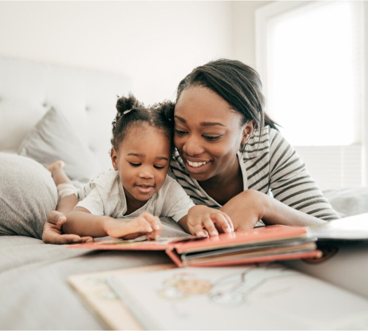 Bright Beginnings - imagen de un padre y su hijo sonriendo mientras leen un libro